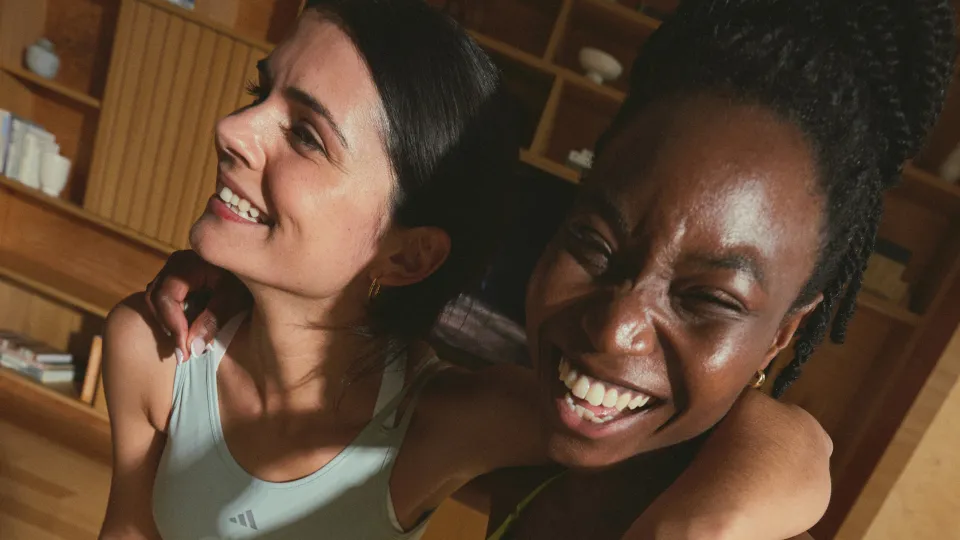 Two happy friends embracing after an at-home workout